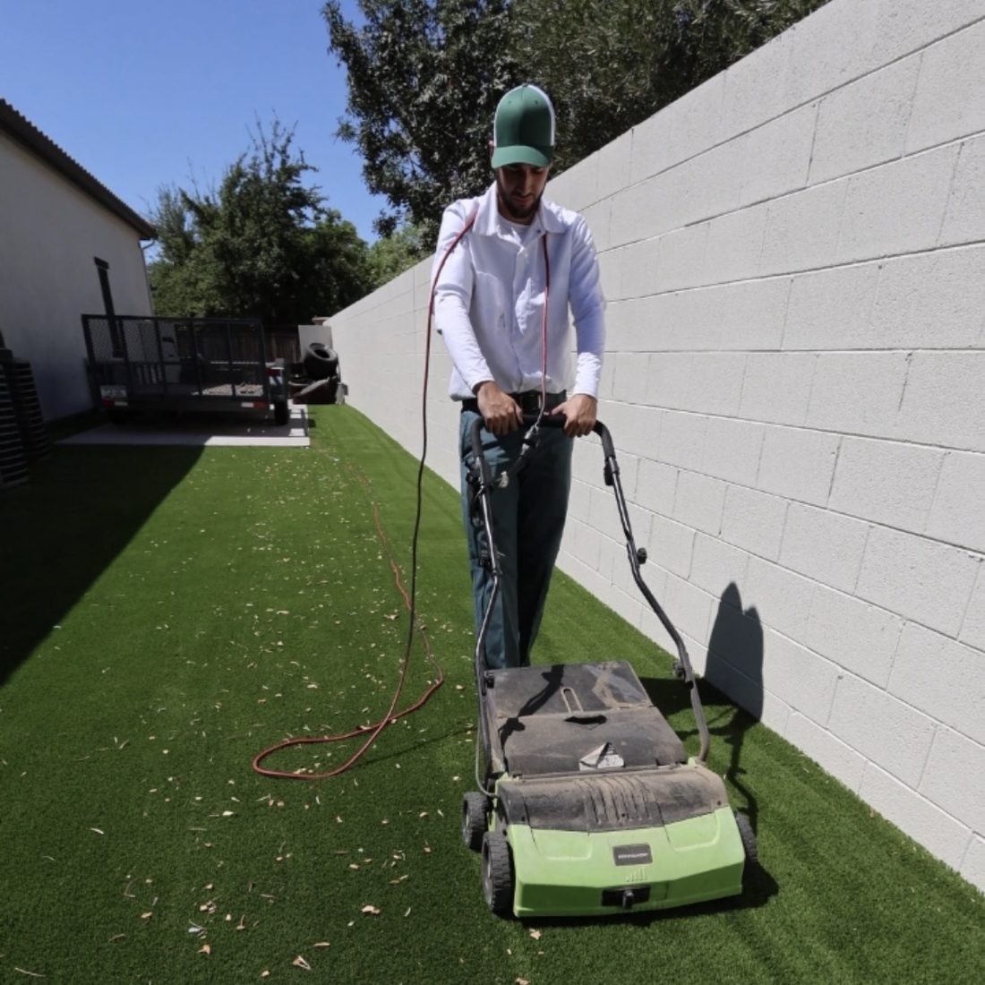 TurfHealth technician power-brushing artificial turf at a Phoenix-area home